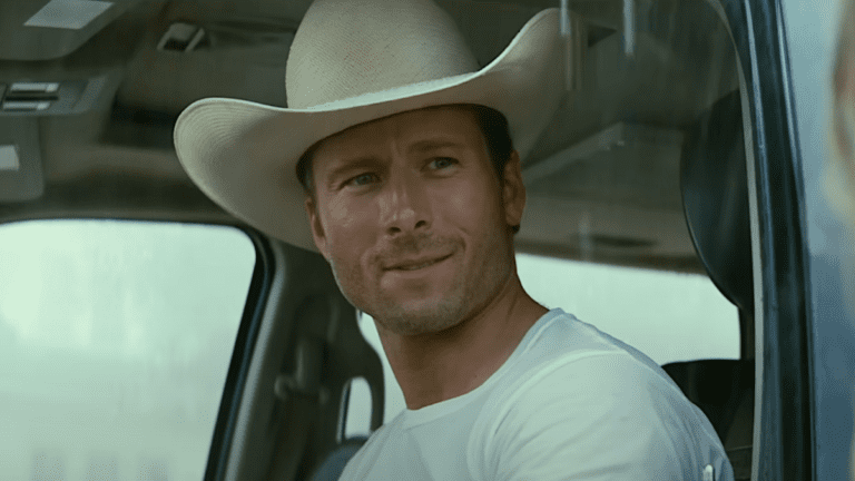 Glen Powell wearing a cowboy hat and driving a car in Twisters 