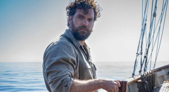 Henry Cavill looking stoic while standing on a boat deck with a cup of coffee in The Ministry of Ungentlemanly Warfare.