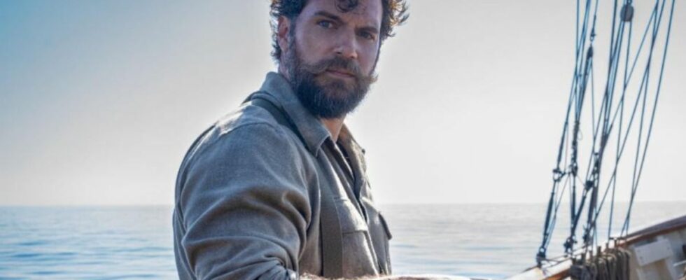 Henry Cavill looking stoic while standing on a boat deck with a cup of coffee in The Ministry of Ungentlemanly Warfare.