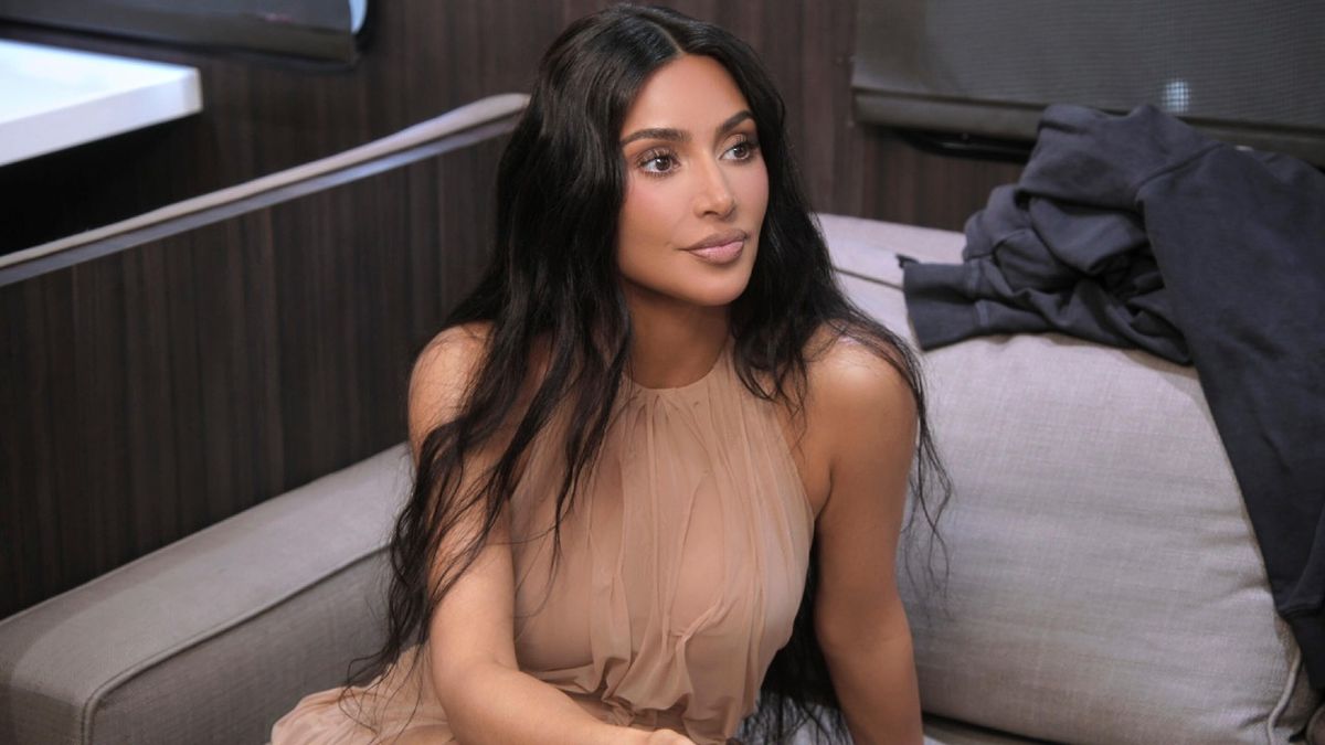 Kim Kardashian sitting and looking up in a press photo for The Kardashians.