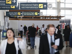 Passagers et signalisation à l’aéroport de Winnipeg.