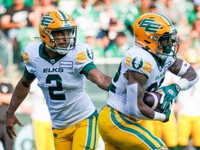 Le quart-arrière des Elks d'Edmonton, Tre Ford (2), passe le relais au porteur de ballon Javon Leake (22) lors de la première mi-temps du match de football de la LCF contre les Roughriders de la Saskatchewan à Regina, le samedi 3 août 2024.