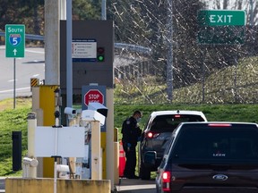 Un agent des douanes et de la protection des frontières des États-Unis s'adresse à un automobiliste de la Colombie-Britannique au poste frontière de Peace Arch à Blaine, dans l'État de Washington, de l'autre côté de la frontière canado-américaine depuis Surrey, en Colombie-Britannique, le 8 novembre 2021. Le ministère de la Sécurité intérieure accélère le délai dont disposent les personnes demandant l'asile à la frontière canado-américaine pour consulter un avocat avant de présenter leur dossier.