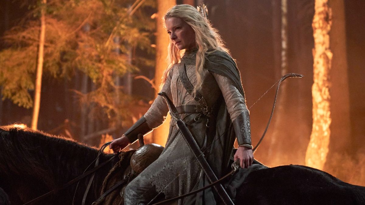 Morfydd Clark as Galadriel riding a horst with fire behind her.