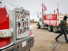 Des manifestants anti-mandat se rassemblent alors qu'un convoi de camions bloque l'autoroute du poste frontière américain très fréquenté de Coutts, en Alberta, le lundi 31 janvier 2022.
