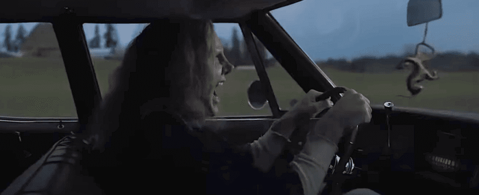 Nicolas Cage in heavy prosthetics driving a car in Longlegs