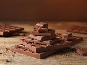 Morceaux et miettes de chocolat savoureux sur une table en bois