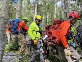 Des secouristes transportent un homme au pied du mont Shavano, dans le Colorado, après avoir passé une nuit froide sur la montagne.