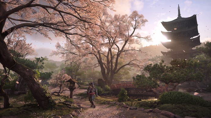 Capture d'écran d'Assassin's Creed Shadows montrant un temple entouré d'arbres en fleurs.