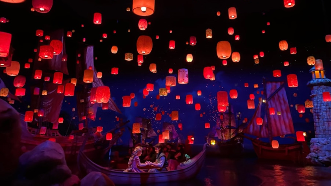 Raiponce et Flynn dans un bateau se tenant la main pendant le festival des lanternes à l'attraction Tokyo DisneySea