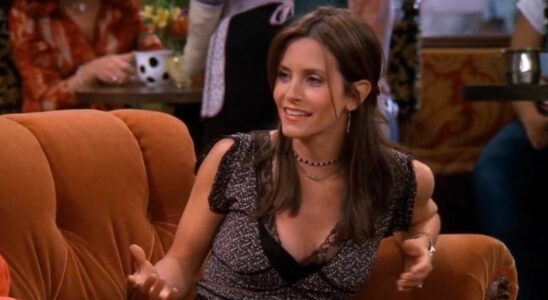 courteney cox as monica geller sitting on the orange couch in central perk in friends.