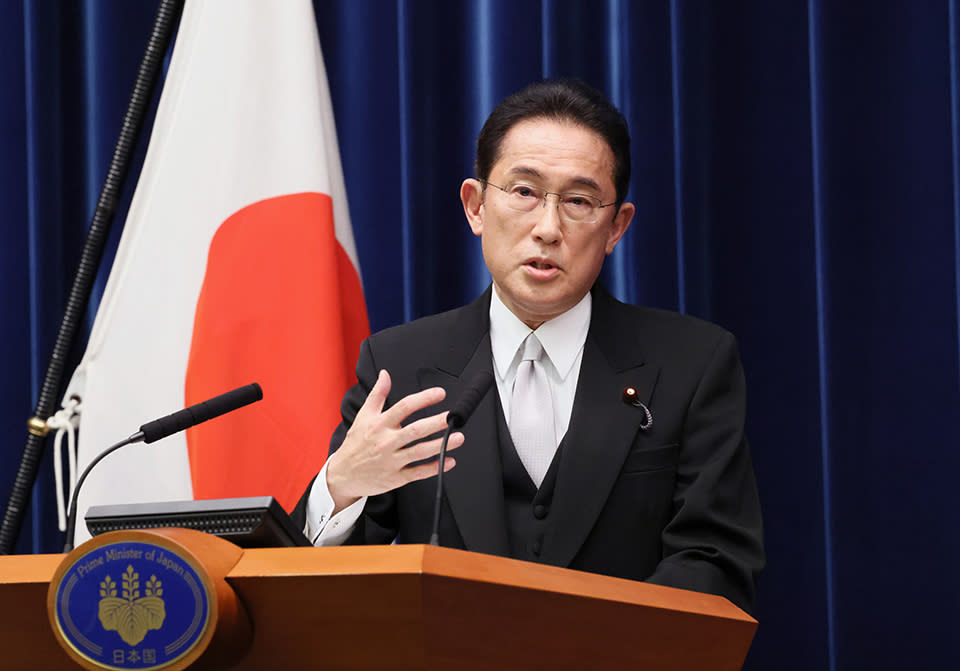 Le Premier ministre japonais Fumio Kishida prononce un discours sur un podium devant le drapeau national.