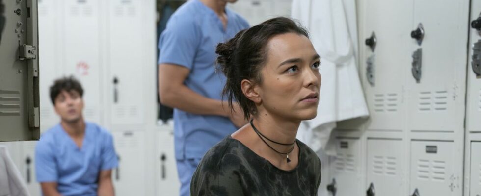 Mika Yasuda (Midori Francis) is shown on Grey's Anatomy with Lucas Adams and Blue Kwan in the background.