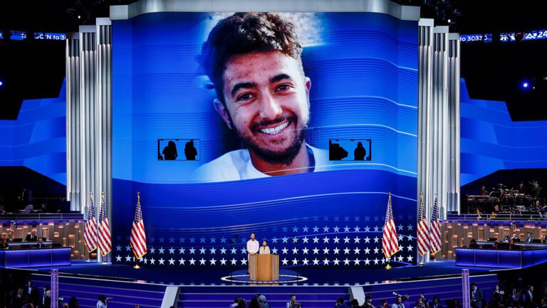 An image of Hersh Goldberg-Polin is displayed as his parents Jon Polin and Rachel Goldberg speak on stage during the third day of the 2024 DNC.