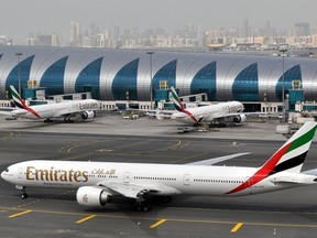 Un avion d'Emirates roule vers une porte d'embarquement à l'aéroport international de Dubaï