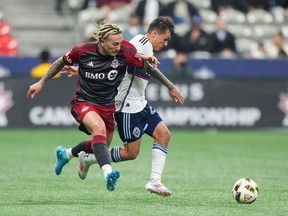 Federico Bernardeschi du Toronto FC, à gauche, et Andres Cubas des Whitecaps de Vancouver se disputent le ballon lors de la première moitié du match de football final du Championnat canadien, à Vancouver, le mercredi 25 septembre 2024.