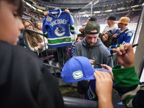 Le gardien des Canucks de Vancouver Thatcher Demko signe des autographes pour les fans après s'être entraîné avec les entraîneurs lors de la journée d'ouverture du camp d'entraînement de l'équipe de hockey de la LNH, à Penticton, en Colombie-Britannique, le jeudi 19 septembre 2024.