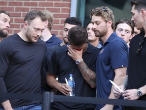 Le joueur des Blue Jackets de Columbus, Cole Sillinger, au centre, réagit lors de la veillée aux chandelles en l'honneur du joueur de hockey des Blue Jackets Johnny Gaudreau, à l'extérieur de la Nationwide Arena à Columbus, Ohio, le jeudi 4 septembre 2024.