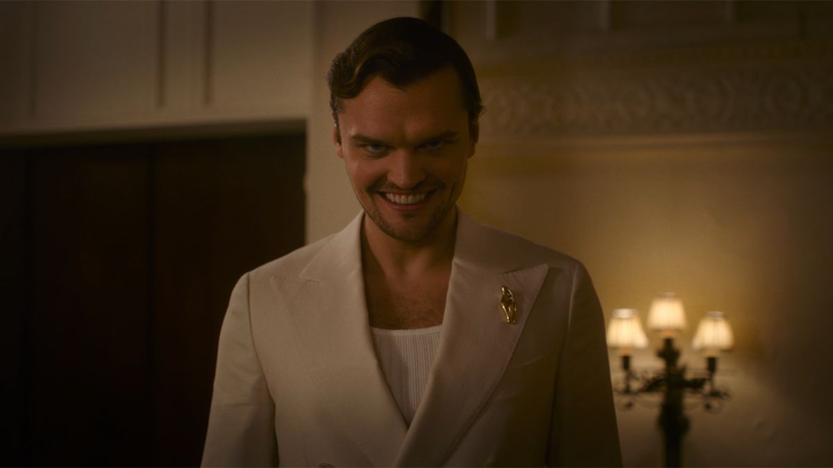 Guy in white suit smiling in Smile 2