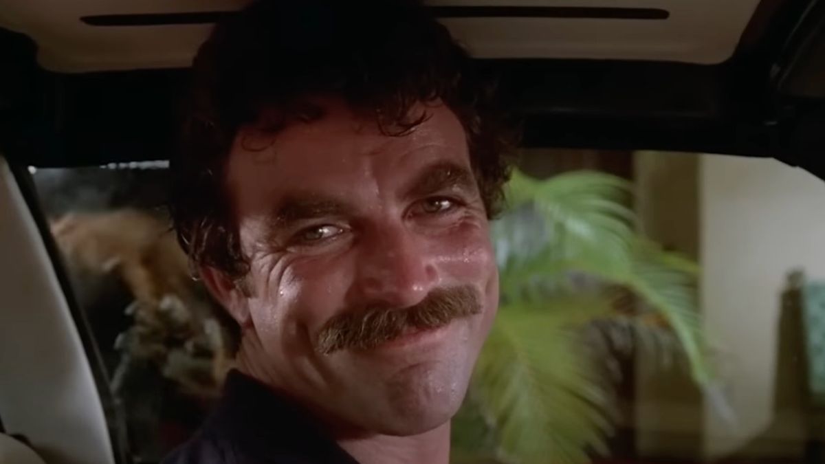 Tom Selleck as Thomas Magnum smiling while driving on Magnum P.I.