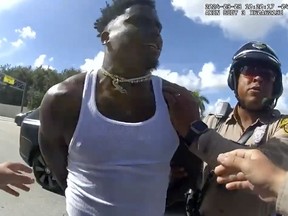 Cette image de caméra corporelle publiée par le département de police de Miami-Dade montre le receveur des Dolphins de Miami, Tyreek Hill, arrêté lors d'un contrôle routier, le dimanche 8 septembre 2024. (Département de police de Miami-Dade via AP)