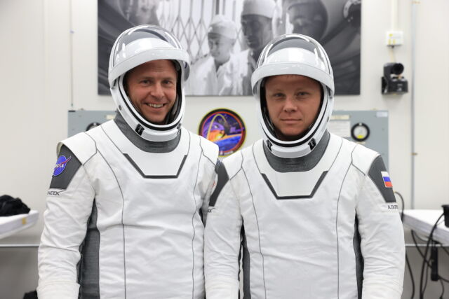 L'astronaute de la NASA Nick Hague et le cosmonaute russe Aleksandr Gorbunov dans leurs combinaisons pressurisées SpaceX.