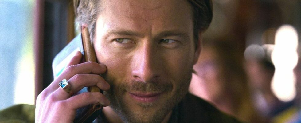 Glen Powell's Gary Johnson speaks on a phone in a close-up photo of his face in a press image for the Netflix movie Hit Man.