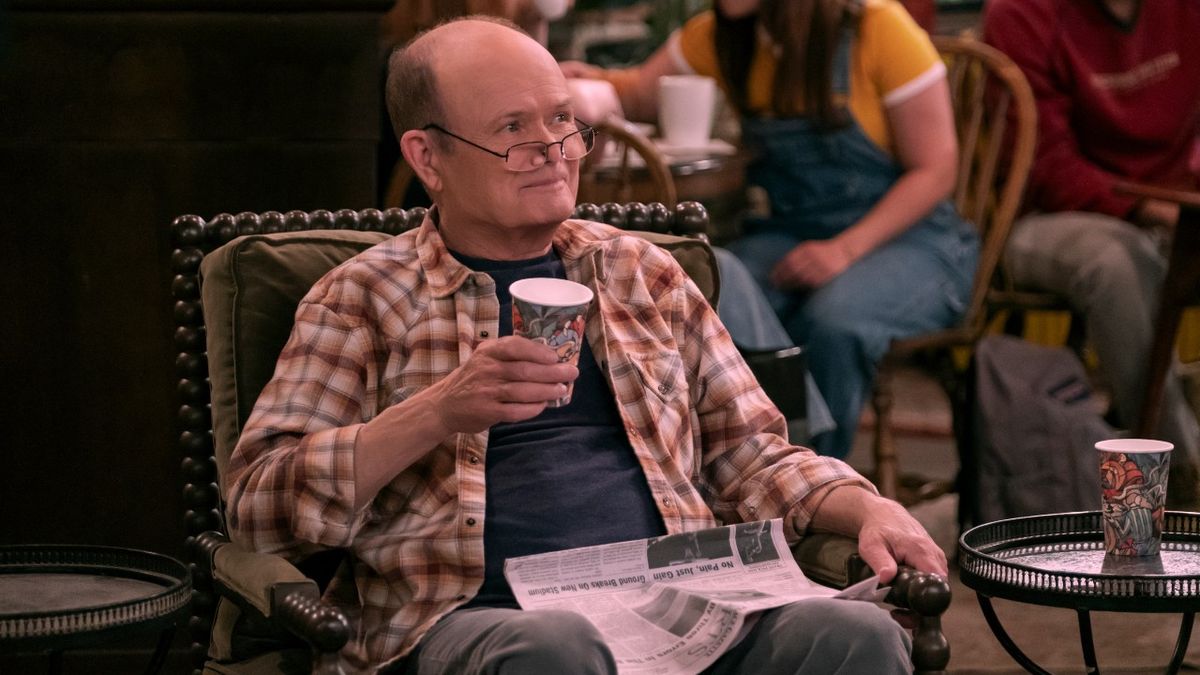 Kurtwood Smith in That &#039;90s show with a newspaper in his lap, he&#039;s holding a coffee cup in his left hand and he&#039;s looking over his glasses. 