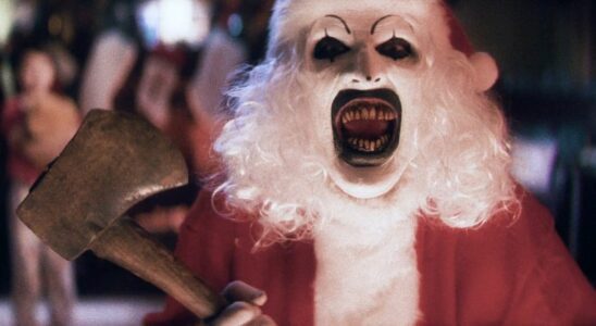 David Howard Thorton as Art the Clown, laughs while dressed as Santa with an axe, in Terrifier 3.