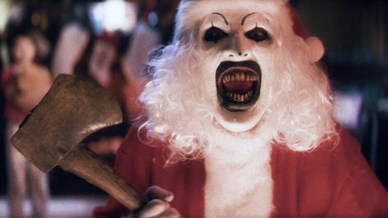 David Howard Thorton as Art the Clown, laughs while dressed as Santa with an axe, in Terrifier 3.