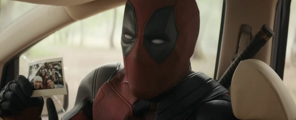 Close-up of Deadpool pointing to Polaroid picture of all of his friends in Deadpool &amp; Wolverine