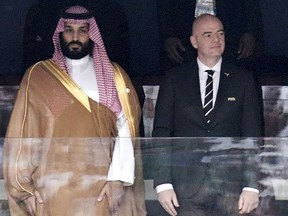 DOSSIER – Le prince héritier d'Arabie saoudite Mohammed ben Salmane, à gauche, et le président de la FIFA, Gianni Infantino, chantent l'hymne avant le match entre la Russie et l'Arabie saoudite qui a ouvert la Coupe du monde de football 2018 au stade Luzhniki de Moscou, en Russie, le 14 juin. , 2018.