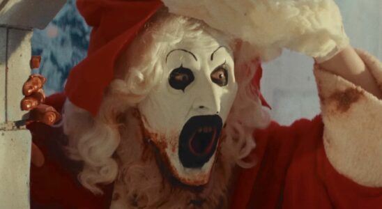 Screenshot of Art the Clown lifting the Santa Clause mask off of his face in Terrifier 3