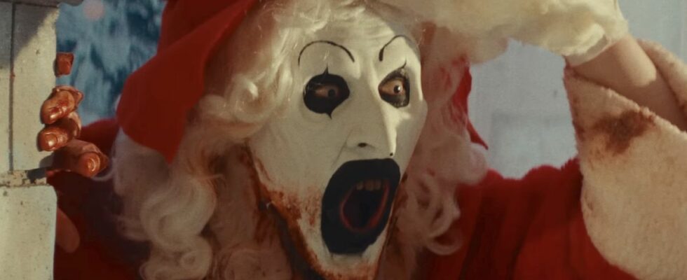 Screenshot of Art the Clown lifting the Santa Clause mask off of his face in Terrifier 3