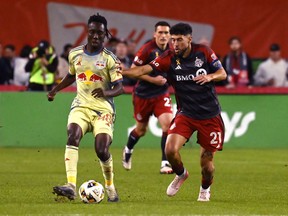 Jonathan Osorio (21) du Toronto FC rivalise pour le ballon contre Ronald Donkor (48) du New York Red Bull lors de l'action MLS à Toronto le mercredi 2 octobre 2024. S'accrochant à la dernière place en séries éliminatoires de la Conférence de l'Est, le Toronto FC semble pour récolter trois autres points précieux lors de sa finale de saison régulière contre Miami, leader de la ligue, à BMO Field samedi.