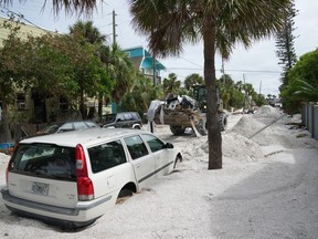 Un chargeur de la Garde nationale de Floride déplace les débris de la section Pass-A-Grille de Saint-Pétersbourg avant l'arrivée prévue de l'ouragan Milton au milieu de cette semaine, le 7 octobre 2024 en Floride.