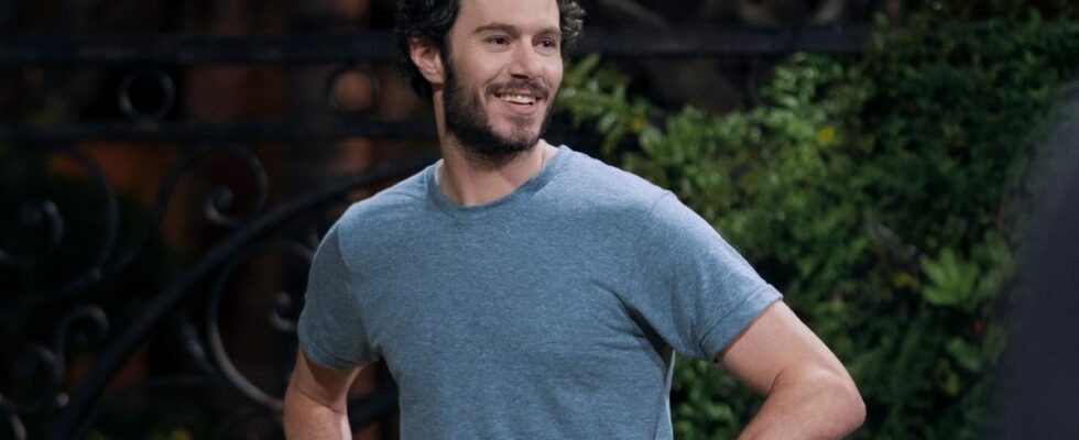 Adam Brody smiling with his hands on his hips in Nobody Wants This.