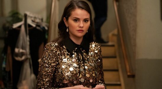 Selena Gomez stands with a look of concern in a gold and black sequin dress in Only Murders in the Building.