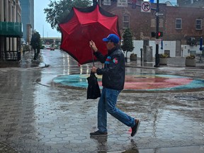 Un homme tient son parapluie dans le centre-ville d'Orlando, en Floride, le mercredi 9 octobre 2024, à l'approche de l'ouragan Milton.