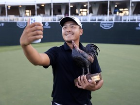 Kevin Yu pose avec un trophée.